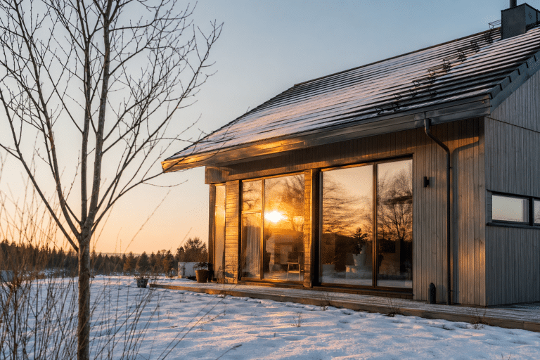 Maison moderne en bois aux grandes baies vitrées enneigée